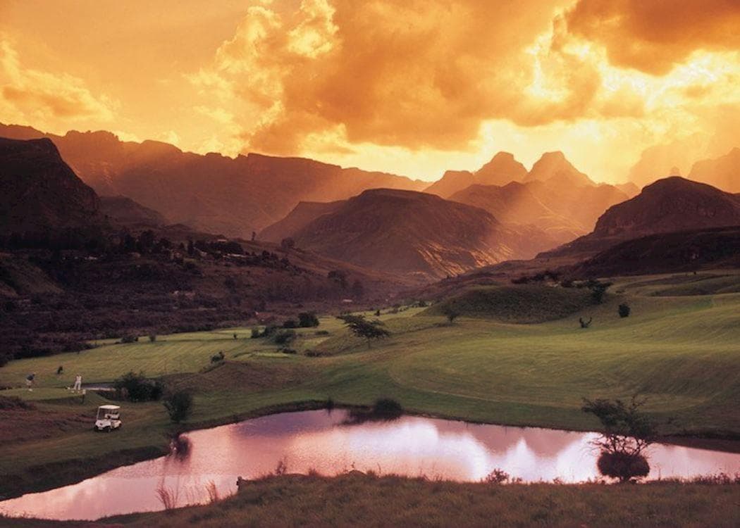 Cathedral Peak rising behind the fairway of the Drakensberg golf course